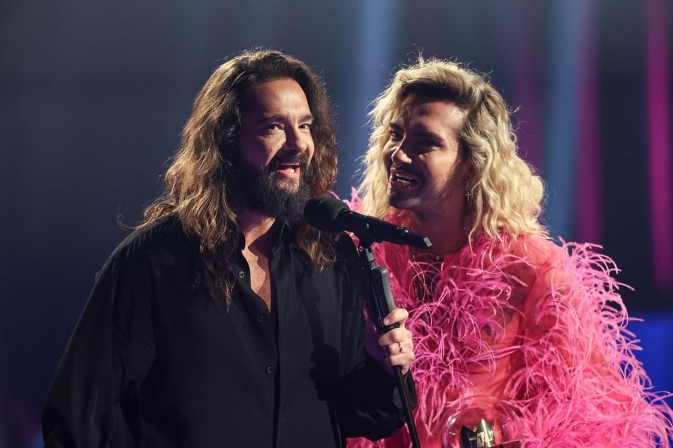 Bill Kaulitz (35, r.) ist bekannt dafür, in extravaganten Outfits aufzutreten. Ob sein nächster Look von Schülern geschneidert sein wird?