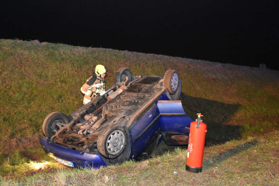 Ein Feuerwehrmann wirft ein Blick auf den verunfallten Wagen.