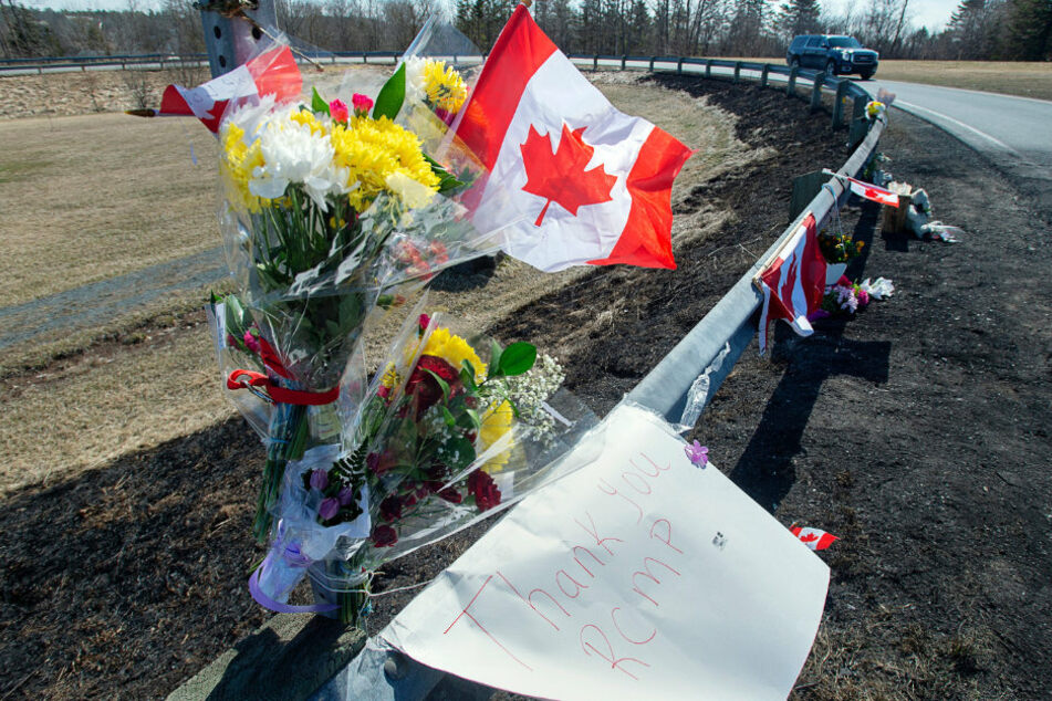 Blumen, kanadischen Fahnen und ein Blatt Papier mit der Aufschrift "Danke Royal Canadian Mounted Police (RCMP)" zieren eine Gedenkstätte.