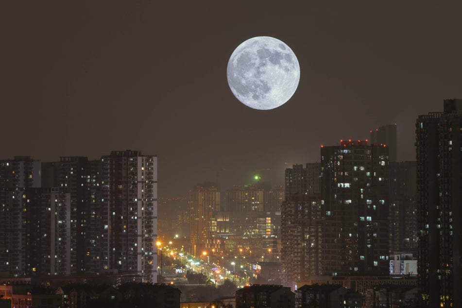 The moon rises above the skyscrapers of Nanjing.