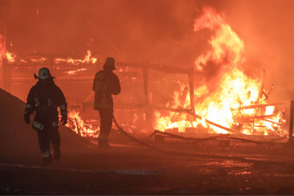 Feuerwehrleute bei den Löscharbeiten. Die Lagerhalle stand beim Eintreffen der Retter bereits in Vollbrand.