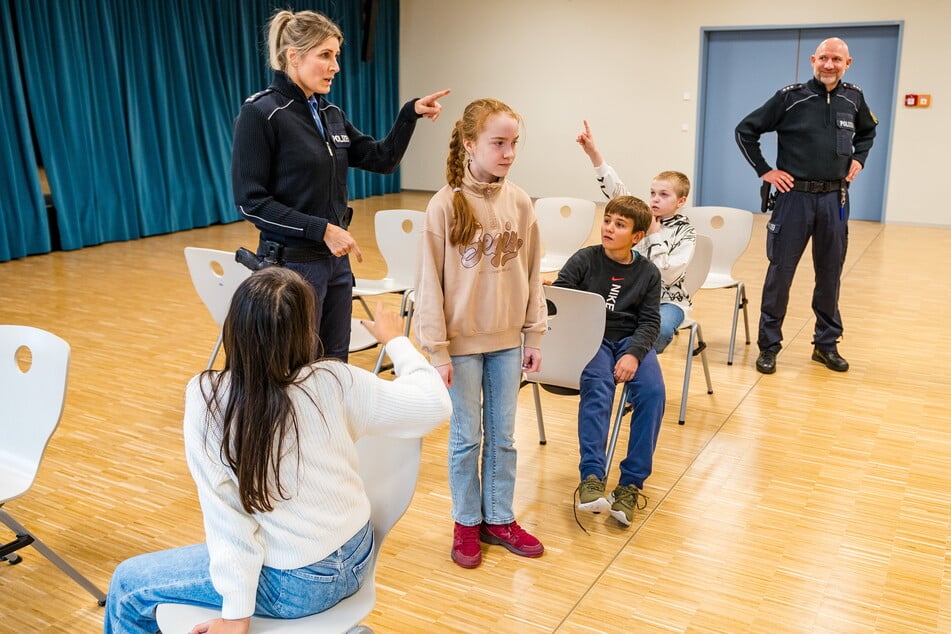 Die Polizeihauptkommissare Kirstin Ilga (44) und Andreas Zucker (45) spielten im Gymnasium Klotzsche mit Fünftklässlern einen Raub nach.