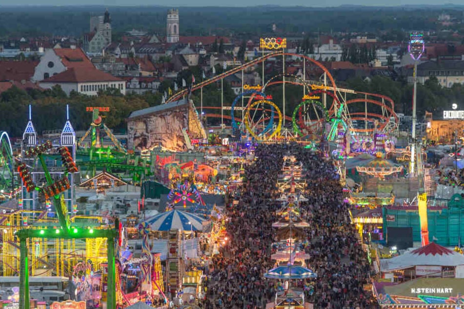 Zahlreiche Besucher sind zur blauen Stunde auf der Theresienwiese, dem Oktoberfestgelände, zu sehen.