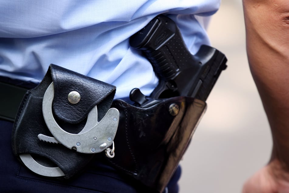Eine Pistole steckt griffbereit im Gürtel eines Polizisten. (Symbolbild)