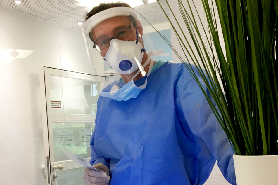 Stuttgart: Der Stuttgarter Allgemeinarzt Cornelius Kübler bereitet sich im Schutzanzug auf einen Corona-Test vor.