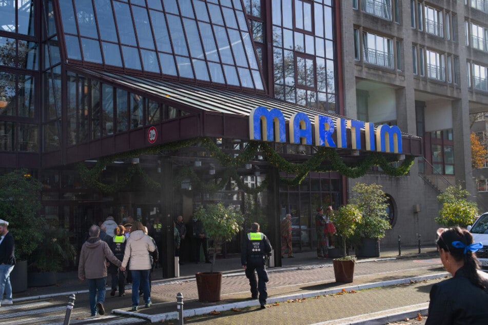 Polizisten betreten neben einigen Karnevalisten das Maritim Hotel am Heumarkt.