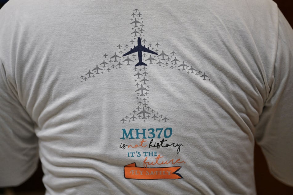 Jiang Hui, whose mother was on board the missing Malaysia Airlines flight MH370, is seen wearing a t-shirt commemorating the accident at his home in Beijing.