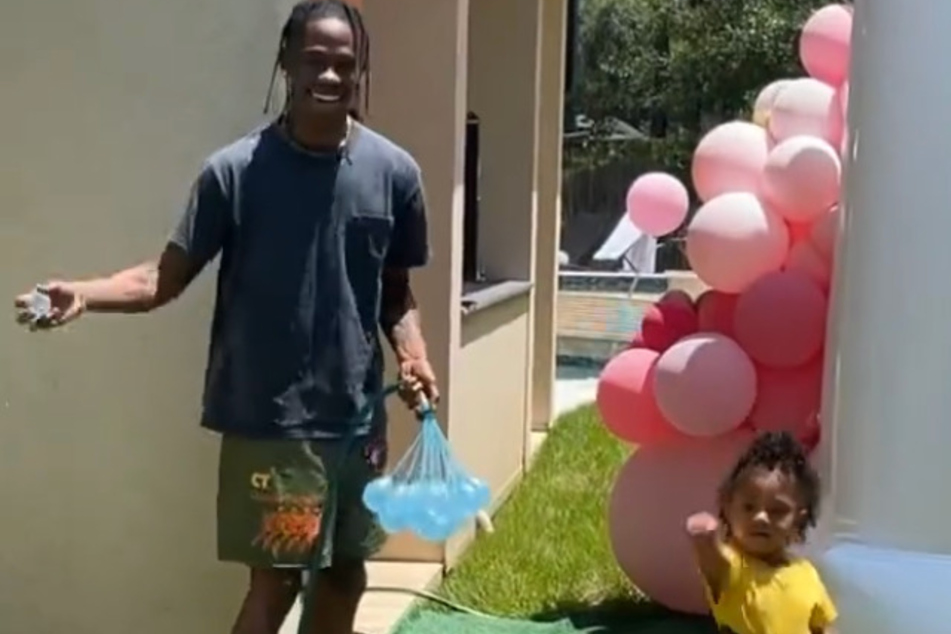 Travis Scott (l.) and Stormi Webster (r.) getting ready to throw balloons at mom Kylie.