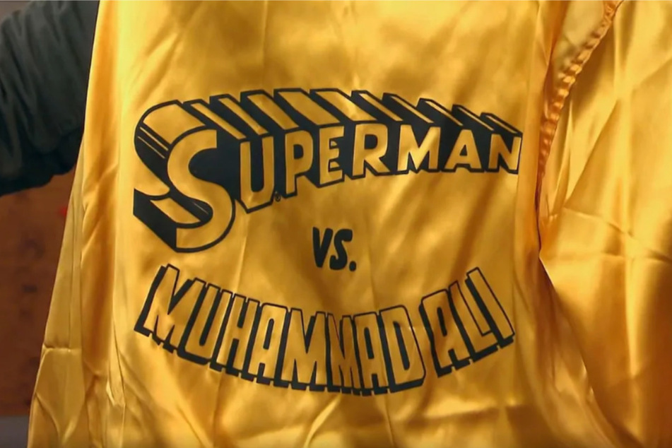 Das Kleidungsstück ist ein Merchandise-Artikel für die Comic-Reihe "Superman vs. Muhammad Ali" und wurde demnach wohl um das Jahr 1978 hergestellt. Sie gehörte einst Angelo Dundee, dem Trainer der verstorbenen Box-Legende.