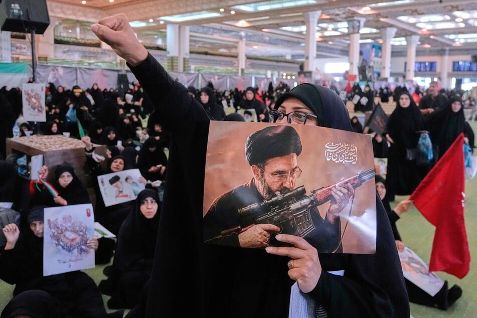 Eine Frau hält ein Plakat des iranischen Obersten Führers Ajatollah Modschtaba Chamenei (56).