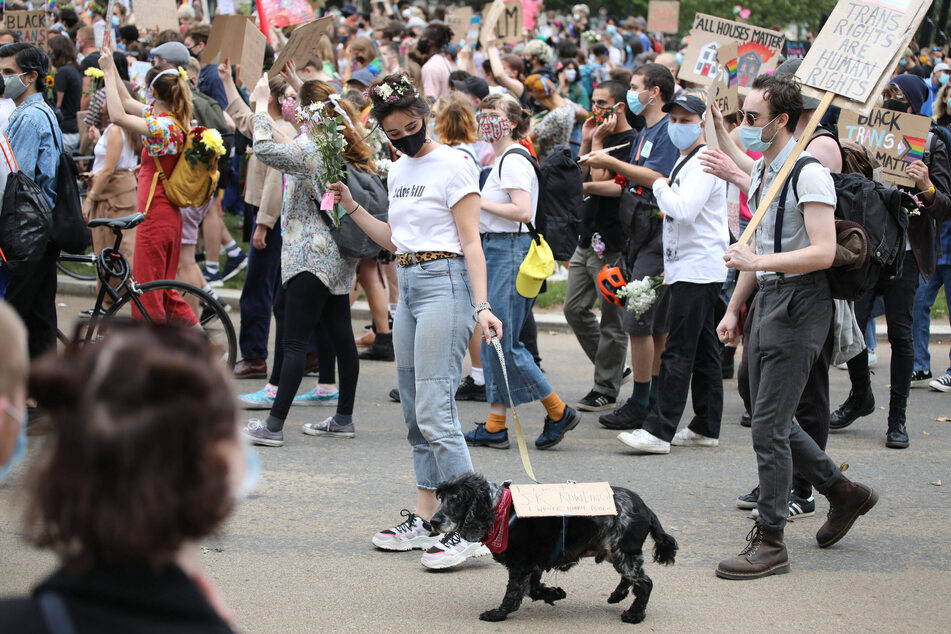 A protester with a dog carrying a "F*ck JK Rowling, I wrote Harry Potter" sign at a Black Trans Lives Matter protest in London.