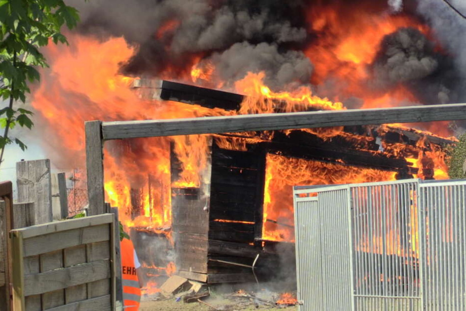 Mit einem Großeinsatz versuchen Feuerwehrleute die Flammen in der Gartenlaube zu löschen.
