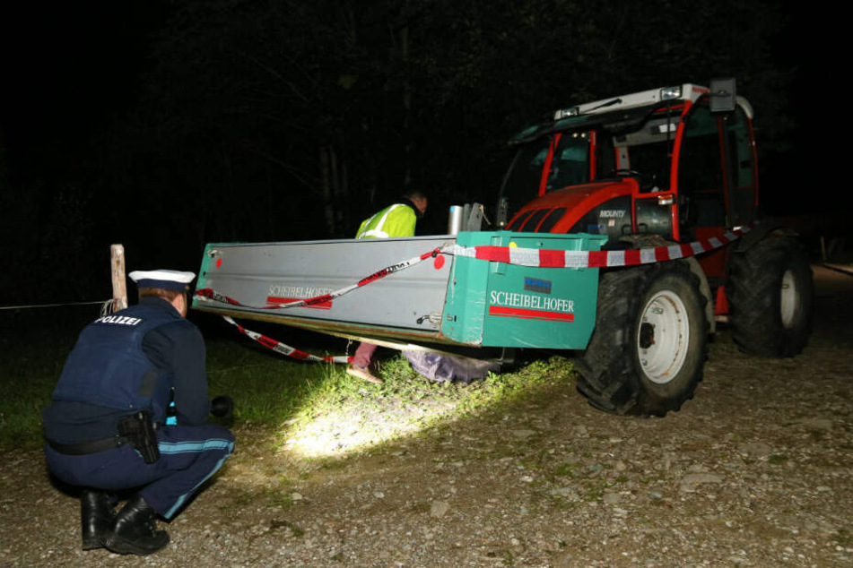 Polizisten durchsuchen den Unglücks-Traktor in Bayern.