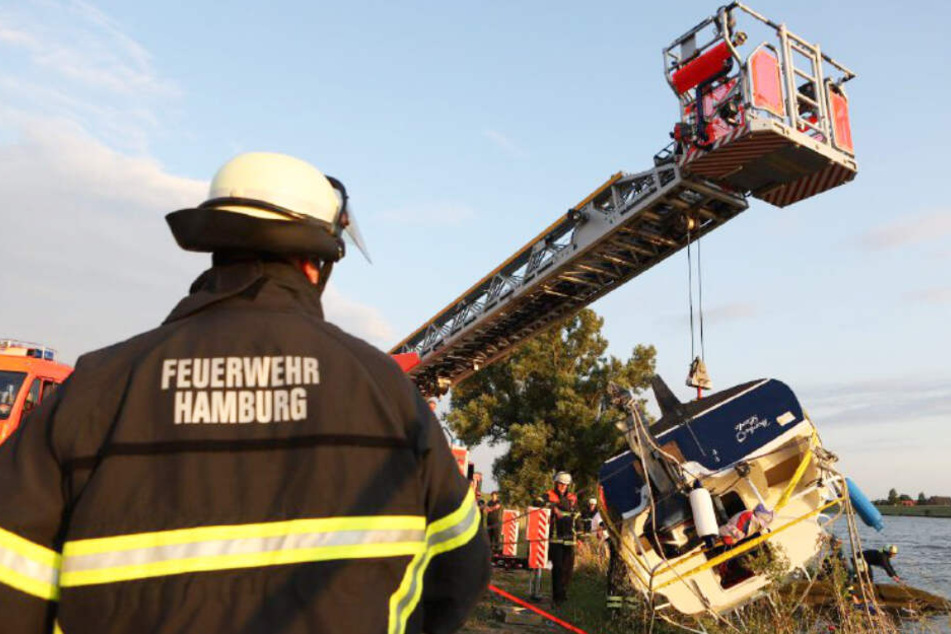 Das gekenterte Boot wird von der Feuerwehr aus der Elbe gehoben.