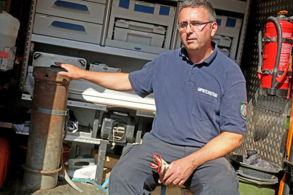 Ein Mitarbeiter des Kampfmittelräumdienstes sitzt neben der geborgenen Phosphorbombe in seinem Wagen.