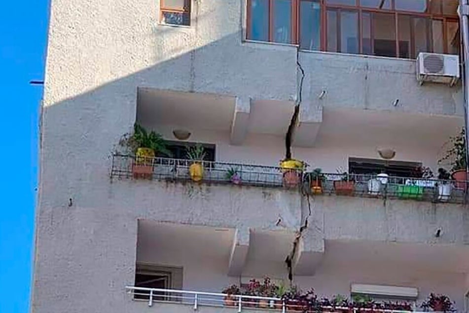 Ein Gebäude ist durch einen vertikalen Riss über mehrere Etagen beschädigt.
