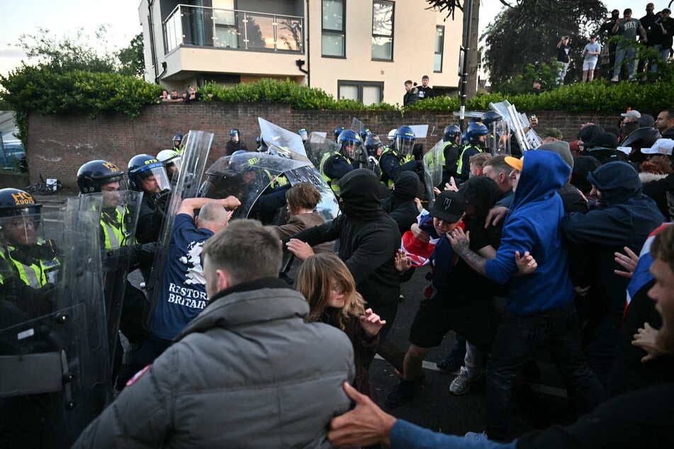 Die Demonstranten gehen auf die Polizisten los, die versuchen, dagegenzuhalten.