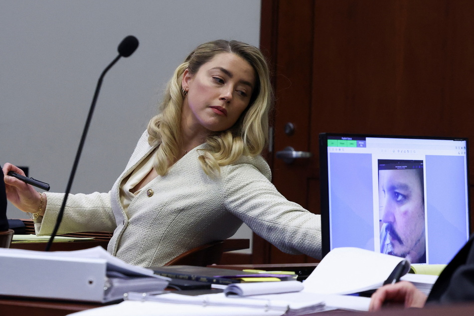 Amber Heard consults her team as Depp's lawyers continue to question the Pirates of the Caribbean star during the shocking defamation trial.