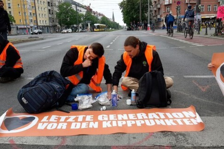 Mit "Betonhänden" sitzen Klimaaktivisten der "Letzten Generation" auf der B109, Prenzlauer Allee in Berlin.