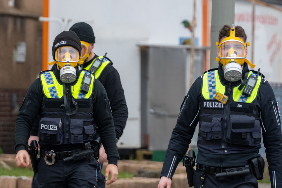 Geschützt durch Gasmasken betreten Einsatzkräfte der Polizei das Gelände im Stadtteil Rothenburgsort.