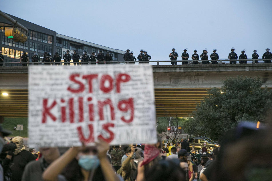 Austin police officers line Interstate 35 to stop Black Lives Matter protestors from walking onto the highway.