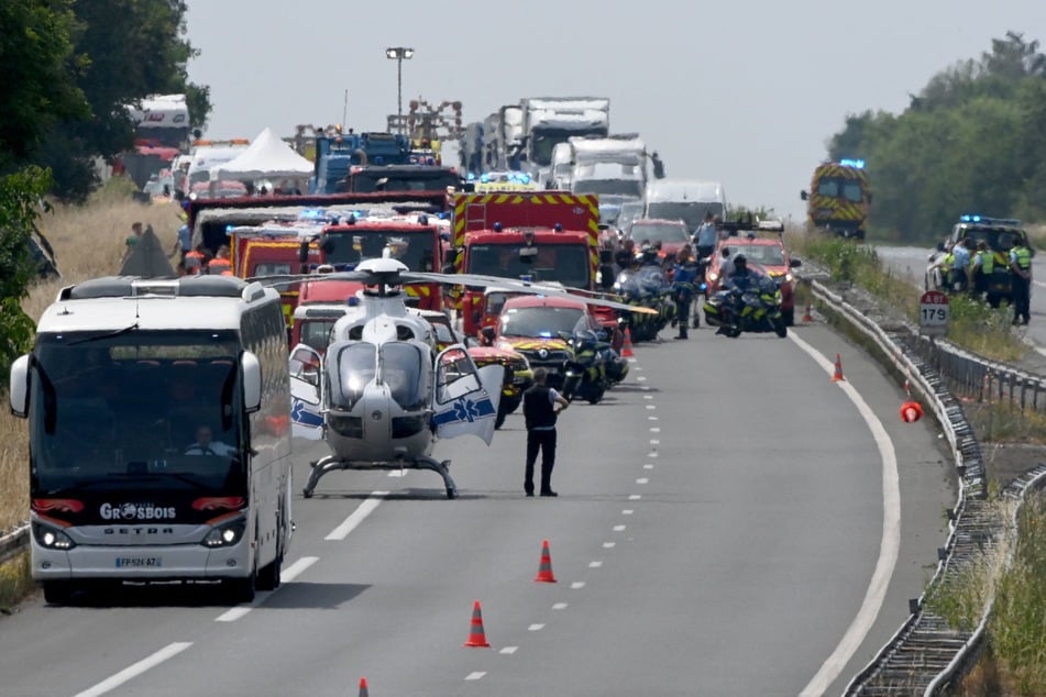 Rettungskräfte, Feuerwehrleute und Polizisten arbeiten an der Unfallstelle eines tödlichen Busunfalls auf der Autobahn A81 in Degre im Nordwesten Frankreichs.