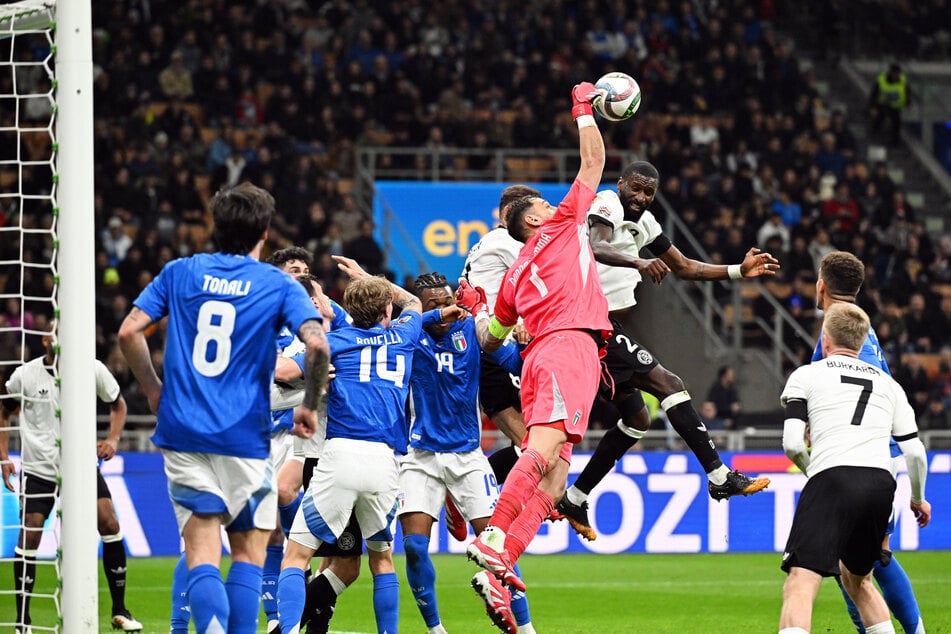 Gianlugi Donnarumma faustet den Ball vor dem heranrauschenden Antonio Rüdiger weg.