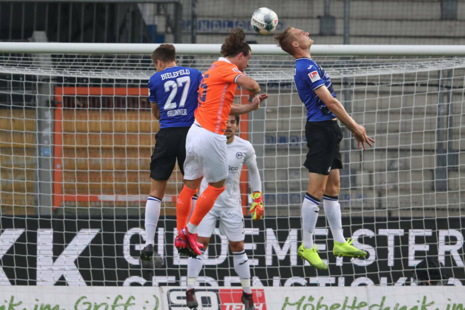 Bielefelds Cedric Brunner (l) und Amos Pieper (r) im Kampf um den Ball mit Yannick Stark (M).
