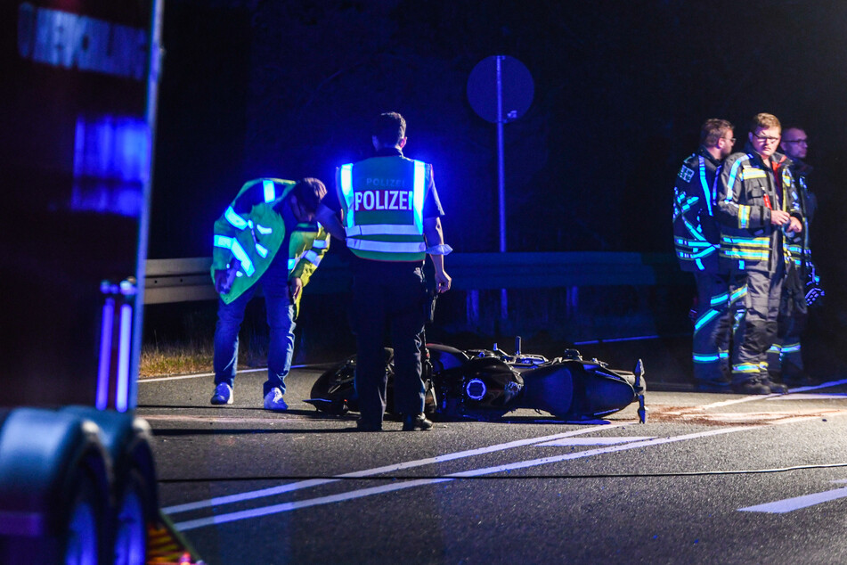 Polizisten untersuchen die Unfallstelle. Die zerstörte Maschine des Verunglückten liegt auf der B14.