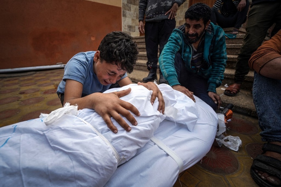 A Palestinian child mourns over the body of a relative killed in Israeli strike at the Nasser hospital in Khan Younis in the southern Gaza Strip.