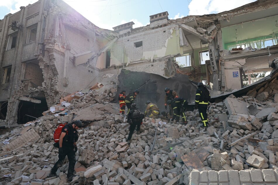Rettungskräfte räumen die Trümmer weg, nachdem eine russische Bombe das Zentrum von Saporischschja in der Ukraine getroffen hatte.