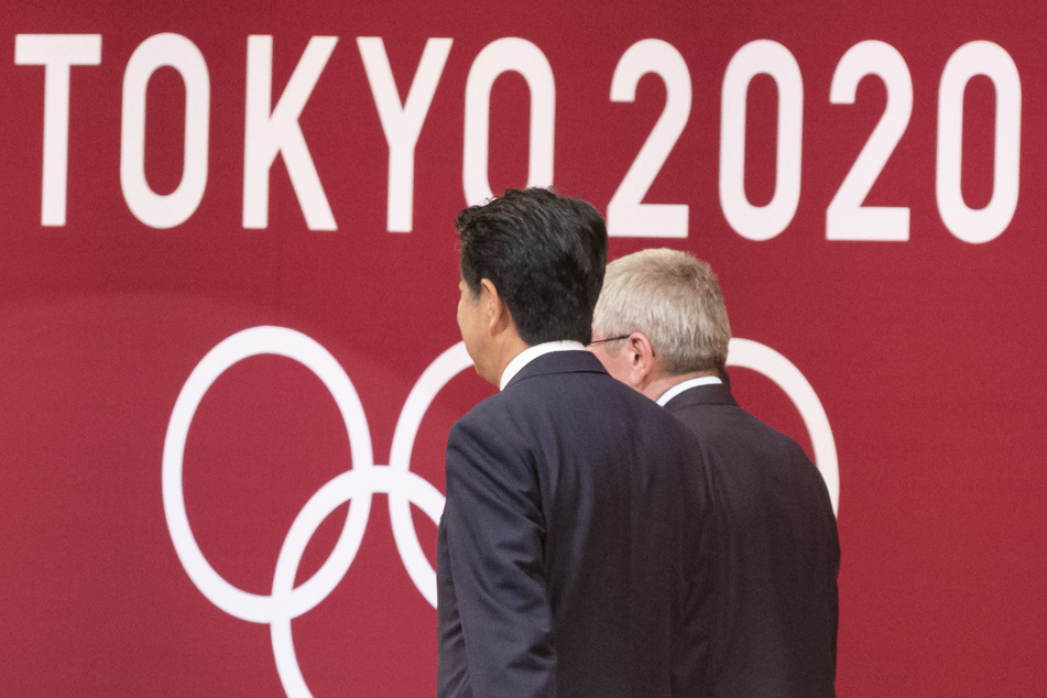 Der Präsident des Internationalen Olympischen Komitees (IOC), Thomas Bach (re.), und der japanische Premierminister Shinzo Abe nehmen an der "One Year to Go"-Zeremonie für die Olympischen Spiele 2020 in Tokio teil. Wegen der Corona-Pandemie finden die Olympischen Spiele in diesem Jahr nicht statt.