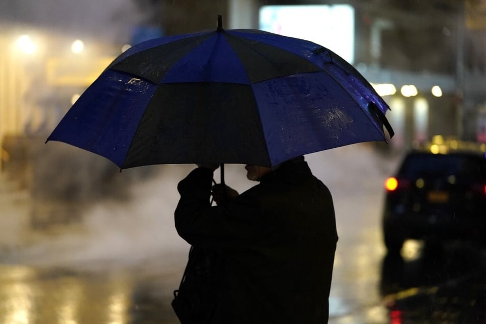 A person holds their umbrella as they walk through Times Square on January 9, 2024, as New York City prepares for a winter storm that could bring flooding to the area.