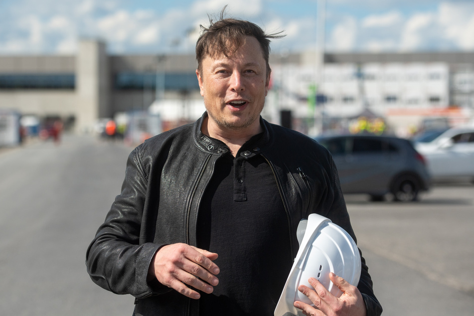 Tesla-Chef Elon Musk (49) steht auf der Baustelle der Tesla-Fabrik und hält seinen Schutzhelm im Arm.
