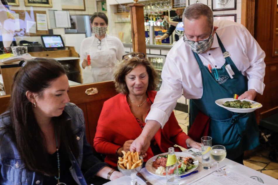 Belgien, Brüssel: Ein Kellner bringt Gästen im Restaurant Chez Léon ihr Essen an den Tisch.