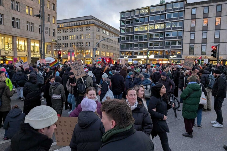 Demostrierende warten mit Plakaten auf den Start.