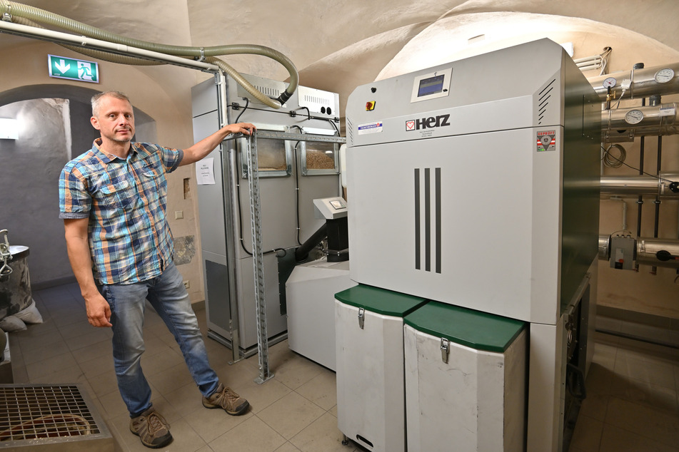 Edgar Lange (49) zeigt den Holzpellet-Kessel in der Oederaner Nahwärmeinsel. Damit kann im Ernstfall zumindest der Gemeindesitz gasfrei versorgt werden.