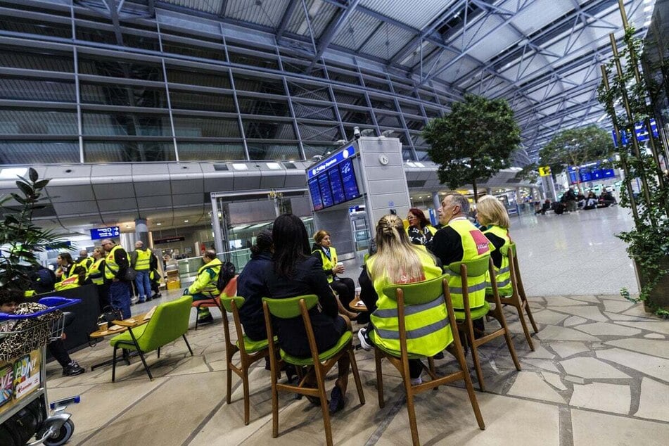 Mitarbeiter des Bodenpersonals sitzen im Abflugterminal des Düsseldorfer Flughafens und streiken.