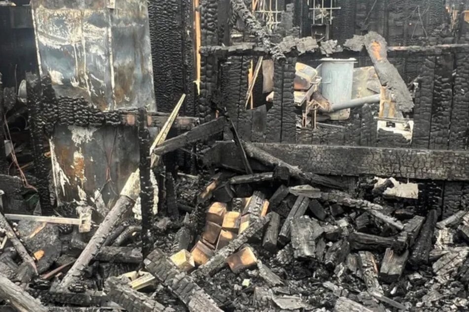 Die Familie steht vor einem Trümmerhaufen.