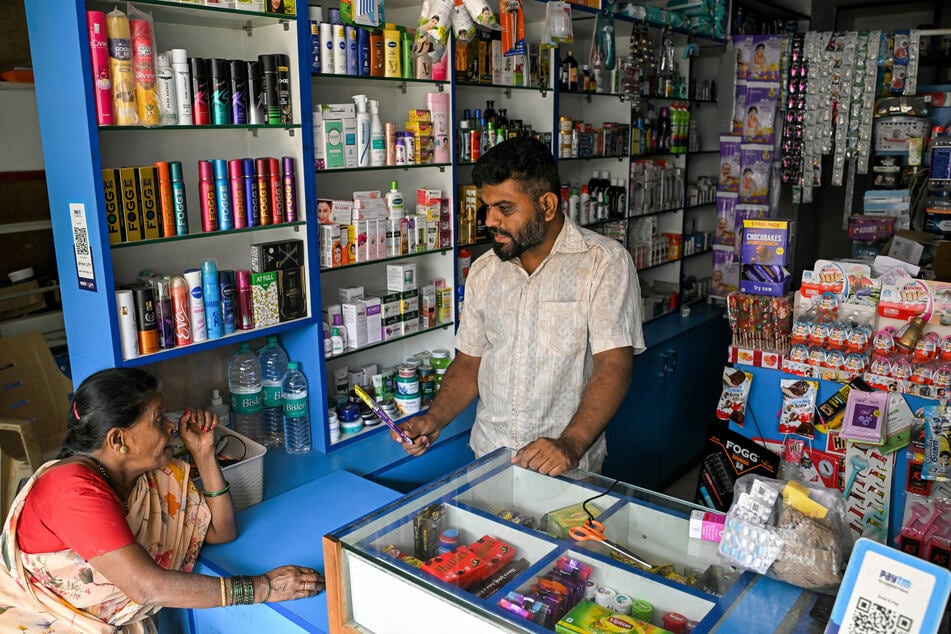 An employee attends to a customer at a pharmacy in Bengaluru on August 6, 2025.