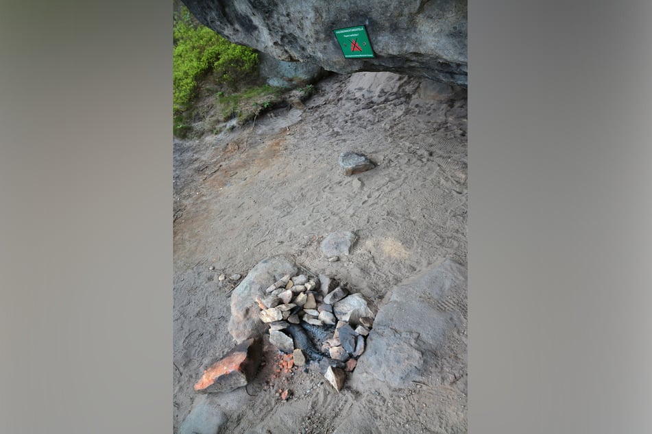Eine illegale Feuerstelle vor dem Schild des Feuer-Verbotes - eine gefährliche Frechheit.