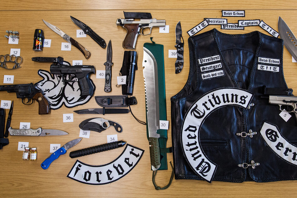 Zahlreiche beschlagnahmte Waffen und eine Leder-Jacke liegen auf einem Tisch im Polizeipräsidium. (Archivbild)
