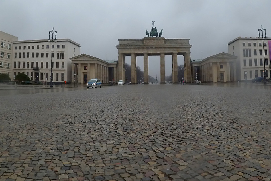 Fast menschenleer ist der Pariser Platz während eines Regenschauers.