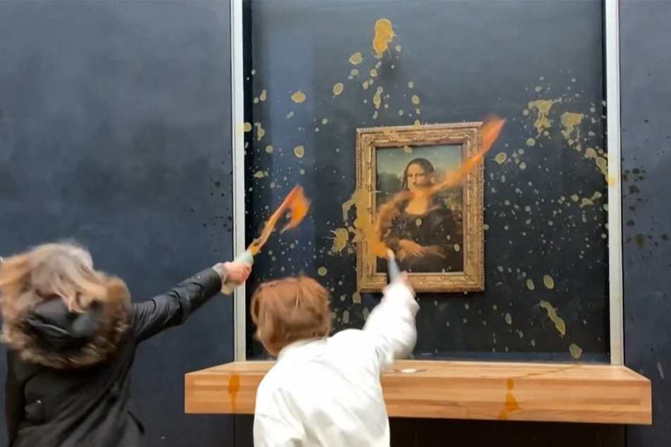Two environmental activists from the collective Riposte Alimentaire (Food Retaliation) hurl soup at Leonardo Da Vinci's Mona Lisa painting, at the Louvre museum in Paris, on January 28, 2024.