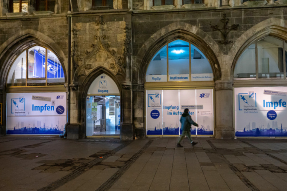 Ein Passant geht in den frühen Morgenstunden an einer Impfstation auf dem Marienplatz in der Innenstadt vorbei.
