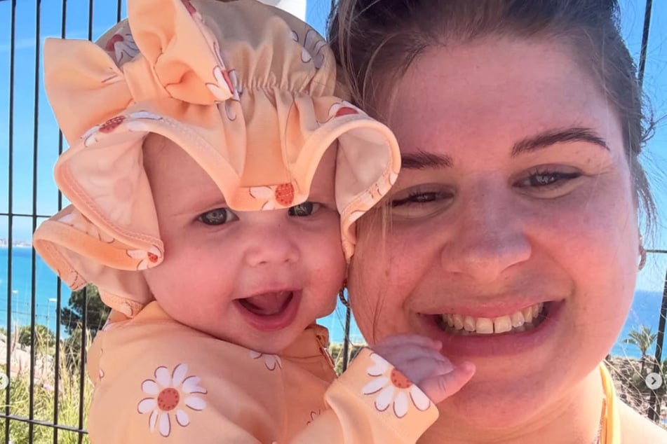 Holly Sansom (30) lächelt mit ihrer Tochter Nora (acht Monate) um die Wette.