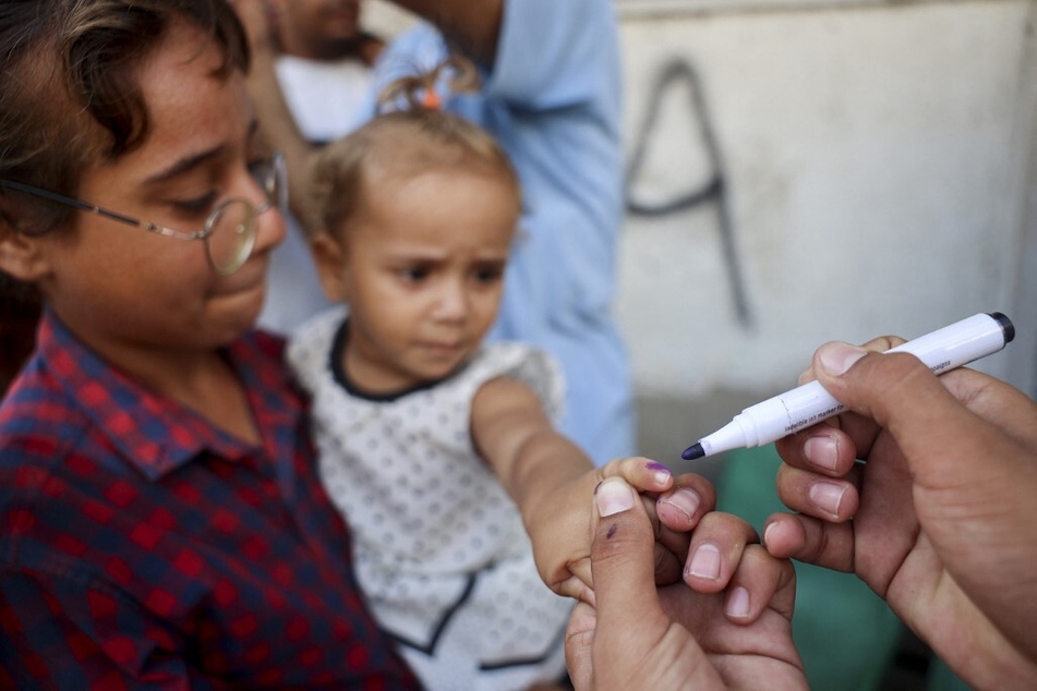 A health worker marks the finger of a Palestinian child that was vaccinated against Polio in Zawayda in the central Gaza Strip.