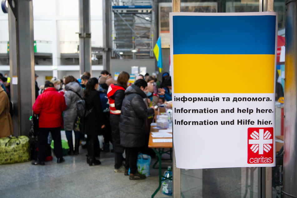 Flüchtlinge aus der Ukraine werden nach ihrer Ankunft am Münchner Hauptbahnhof von Helfern empfangen.