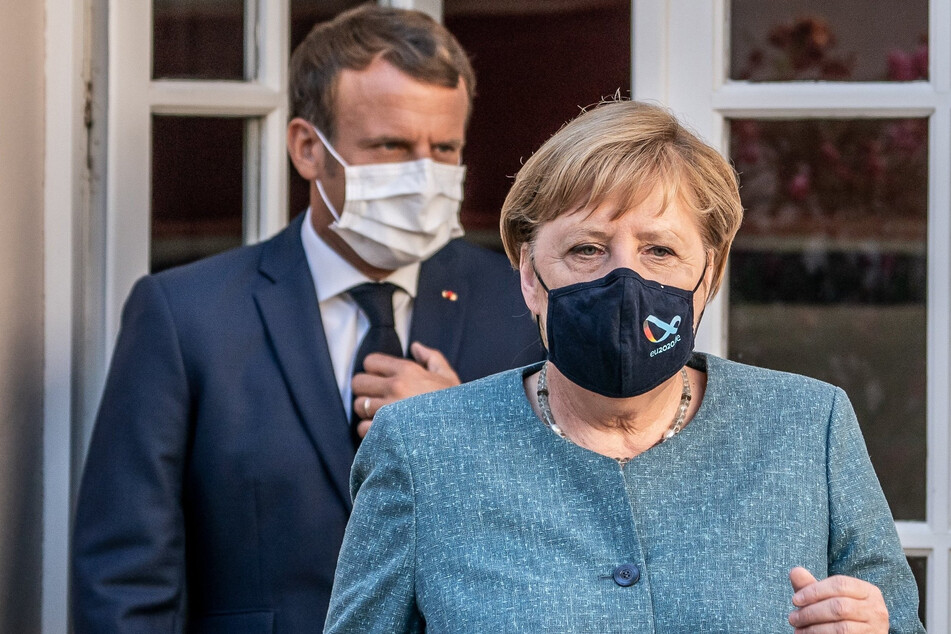 Emmanuel Macron, Präsident von Frankreich, kommt hinter Bundeskanzlerin Angela Merkel (CDU), zu einer Pressekonferenz.