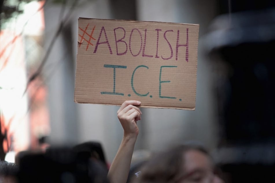 A protester holds up a sign reading "Abolish ICE," in reference to US Customs and Immigration Enforcement.